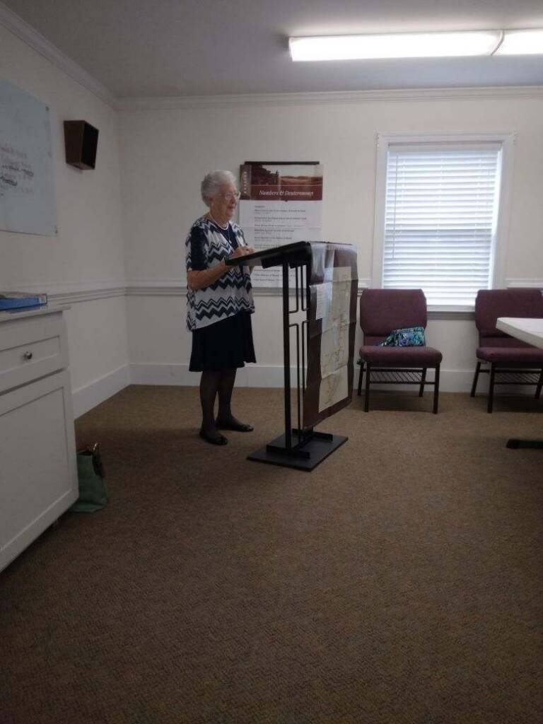 Woman leading Women's Ministry meeting at Rawls Baptist church, standing at a podium