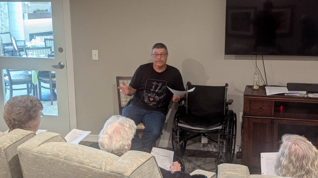 Church member at Rawls Baptist Church giving a lesson to Calyx Senior Living residents in a theater room.