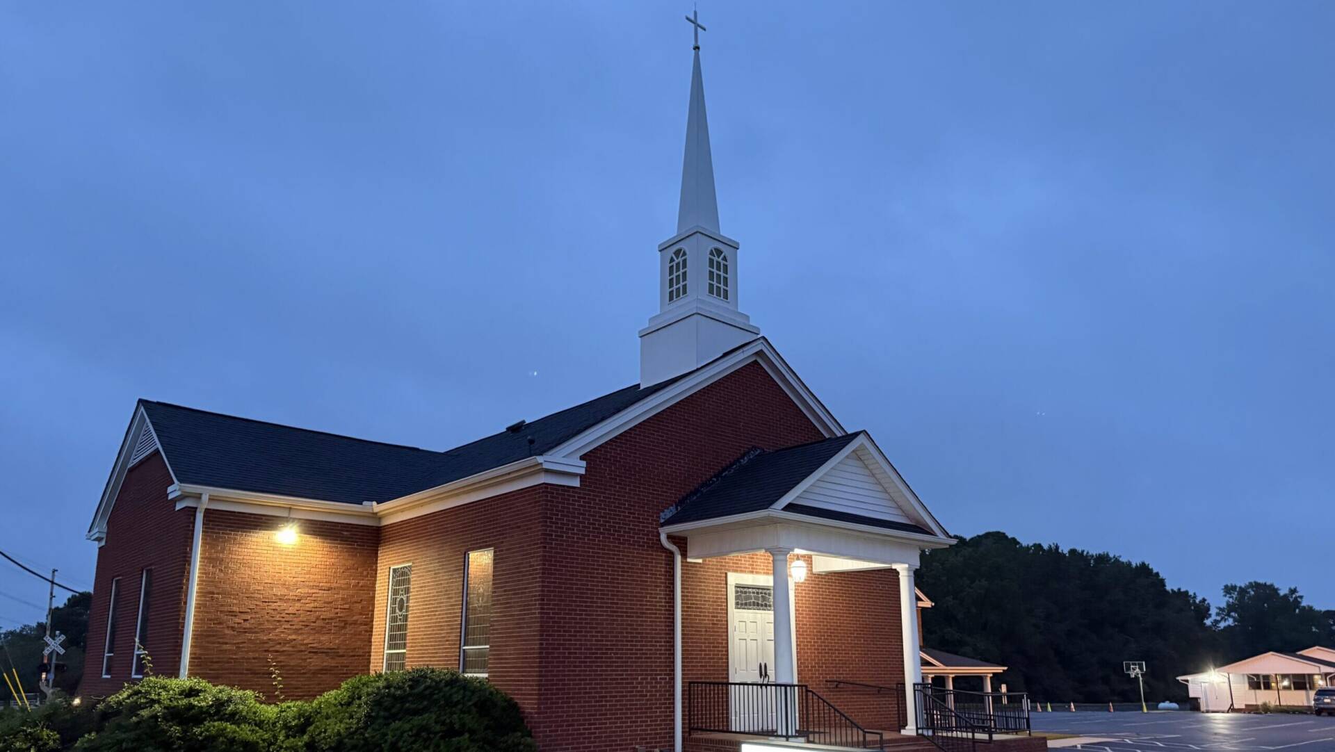 Rawls Baptist Church in Evening just before sunset with church lights glowing faintly.
