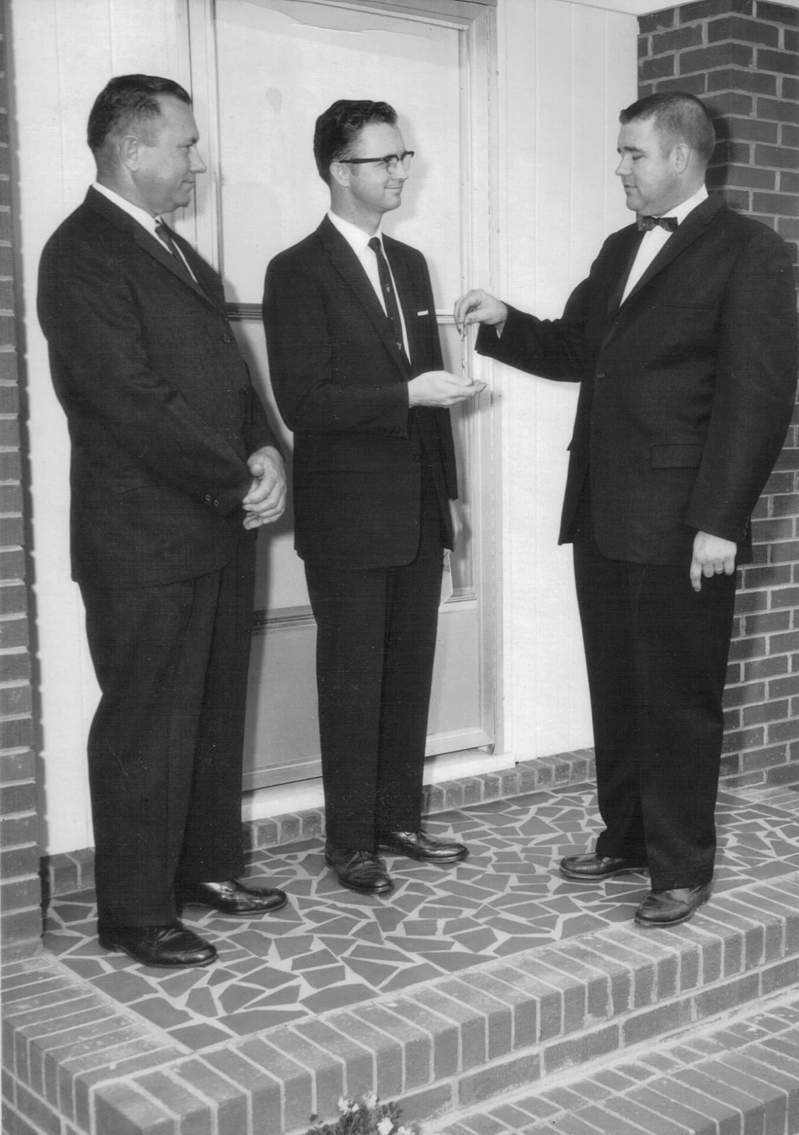 Church leaders gathered on the parsonage steps as Rev. Robert L. Clark received the keys.