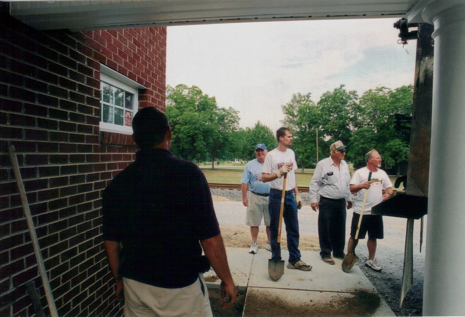 Church members working with shovels and tools during a volunteer workday.