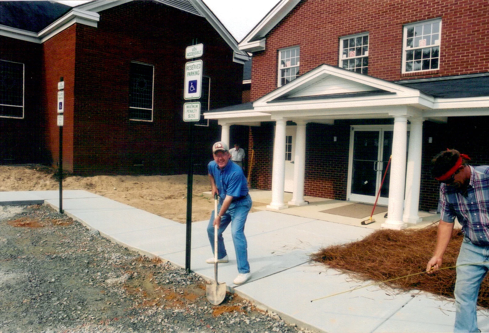 Volunteers installing sidewalks and accessible parking signs.