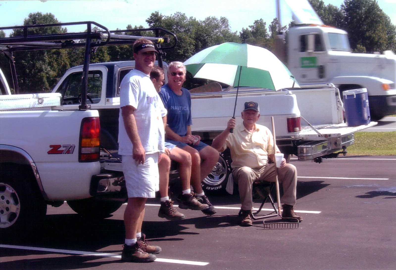 Volunteers resting together in the parking lot after outdoor work.
