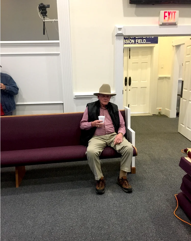 Mr. Smith seated in one of the new church pews.