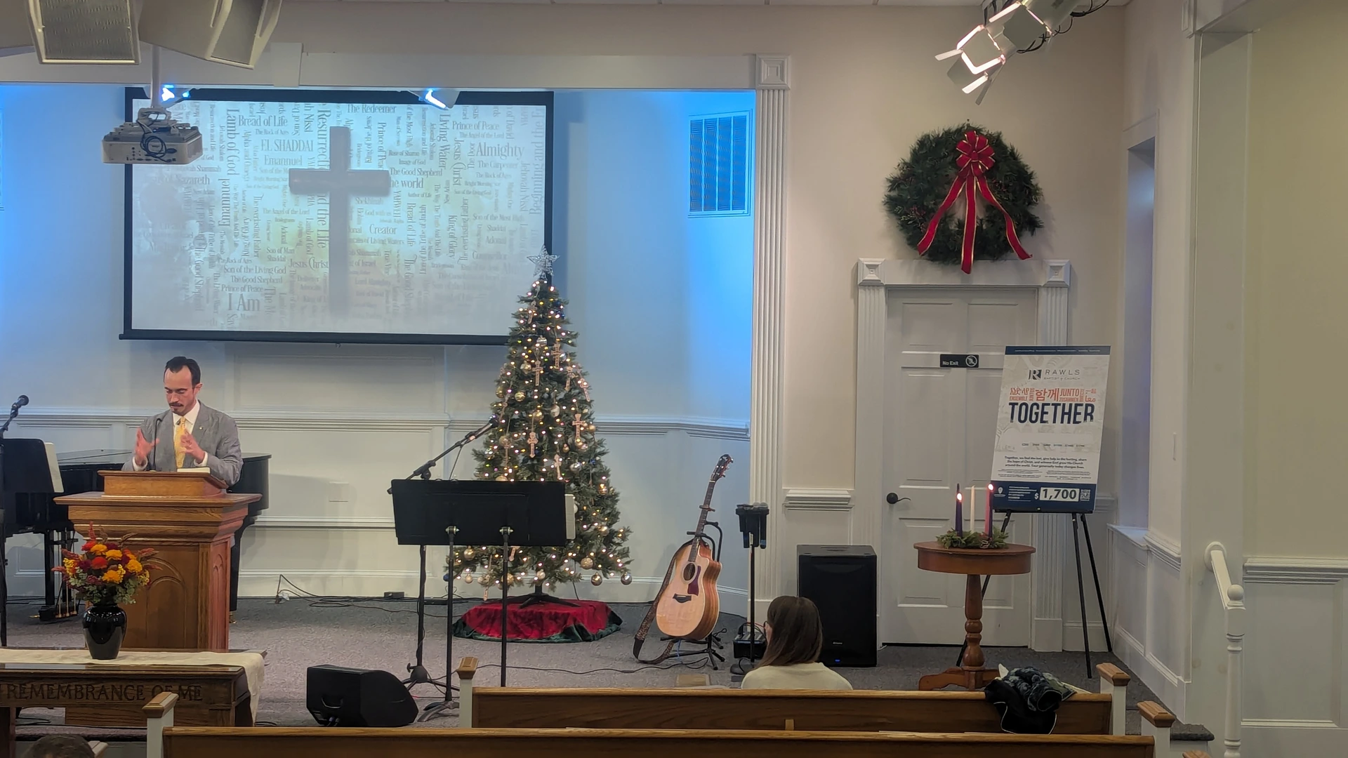 Pastor Brandon preaching from the pulpit beside the Christmas tree during a Christmas service at Rawls Baptist Church.