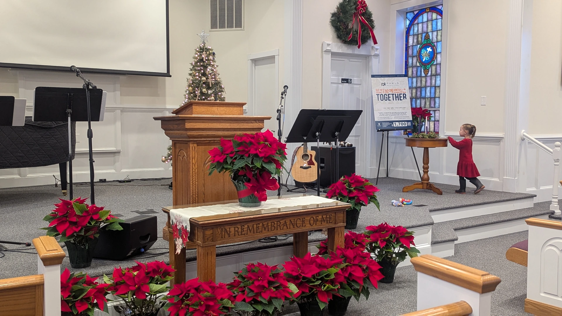 The Rawls Baptist Church sanctuary decorated with poinsettias, a Christmas tree, wreath, and Advent candles.