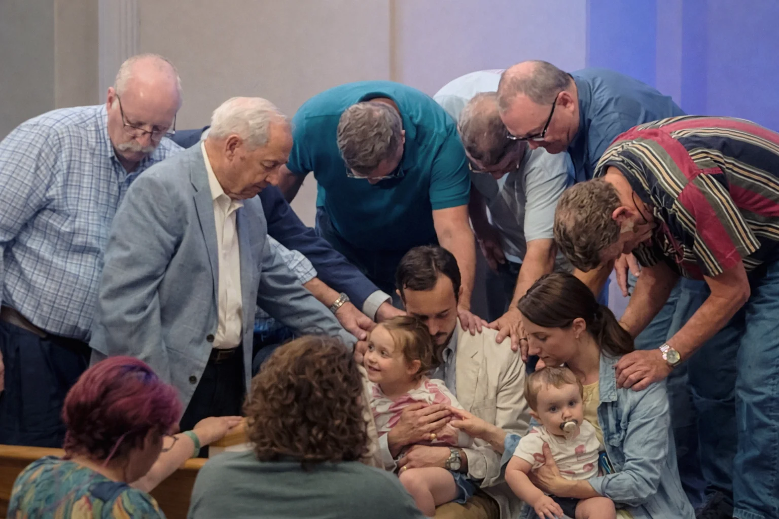 Deacons gathered around the pastor and his family in prayer during revival at Rawls Baptist Church.