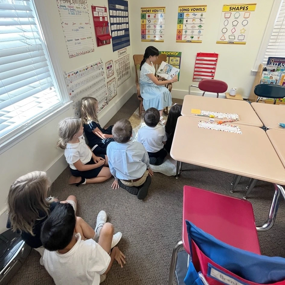 Velos student reading to classmates during a classroom activity.
